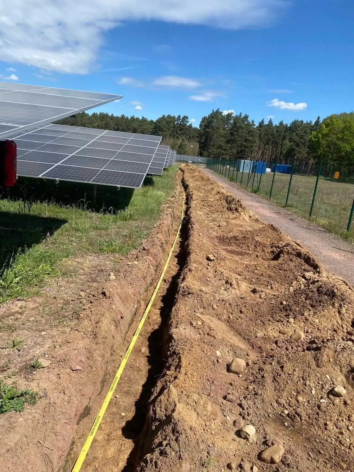 Kabelgraben mit Warnband entlang einer Solaranlage