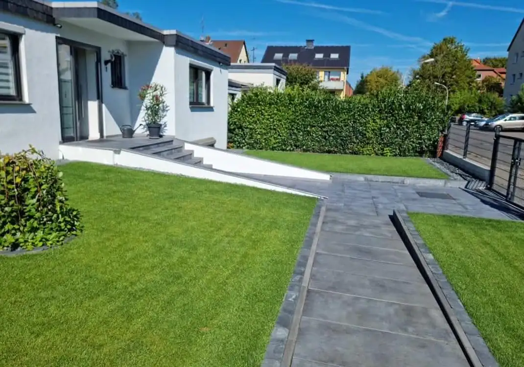 Vorgarten nach dem Umbau: Rasen und Plattenweg zur Haustür